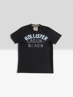 Hollister t shirt - Snygg svart t-shirt från Hollister med stort tryck 'HOLLISTER LAGUNA BEACH' i vitt och ljusblått på bröstet. Klassisk rund hals och korta ärmar. Perfekt till jeans eller shorts för en avslappnad look.