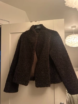Brun teddyjacka från Gina Tricot - Mysig brun teddyjacka från Gina Tricot i storlek M. Funkar även jättebra som S. Jackan har en fluffig och mjuk struktur med rak passform och långa ärmar. Stängs med knapp framtill och har en enkel, stilren design. 