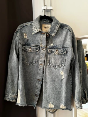 Jeansjacka  - Blå baggy jeansjacka från FB Sister i storlek S. Helt ny och aldrig använd, men utan prislapp. Säljes då den inte kommer till användning.  Katt finns i hemmet, produkten rollas av så gott det går.