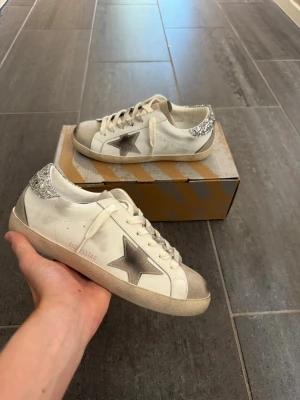 Golden Goose Superstar - Hej, säljer nu min tjejs Golden Goose skor som hon köpte på Vinted med artikelverifiering. Dessvärre så passade de inte så jag hjälper henne att sälja vidare dom. Dust bag och skokartong ingår självklart. Tveka inte på att höra av dig vid frågor! Mvh