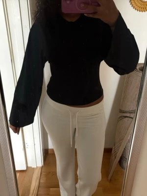 Svart långärmad topp med ballongärm - Snygg svart topp med långa ballongärmar och rund hals. Modellen är croppad och har en stilren look som passar till många outfits. Perfekt för dig som gillar trendiga och enkla plagg.