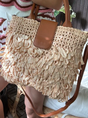 Strandväska naturligt raffia papper - Strandväska i naturligt raffia papper ☀️Stängs med dragkedja och knapp, finns en liten innerficka och ett extra justerbart  axelband.