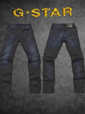 G-Star Raw 3301 Slim W28/L32 mörkblå jeans - ❌ Passformsbilder skickas ej. Se mått!Säljer ett par mörkblå slim fit jeans från G-Star med klassisk femficksdesign och snygga slitningar på framsidan. Jeansen har en diskret logga på bakfickan och är tillverkade i stretchigt denimtyg för extra komfort.💬 Prisförslag välkomnas. 🚫 Rökfritt & djurfritt hem. 📦 Skickas inom 24 timmar. 😱 Smutsfläckar kan förekomma.