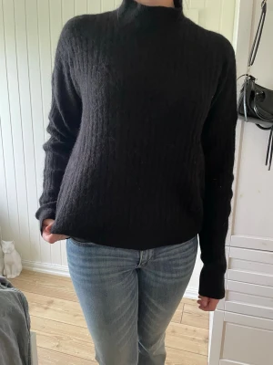 Svart stickad tröja med hög hals - Mysig svart stickad tröja med hög hals och lång ärm. Tröjan är i storlek xs köpt från H&M