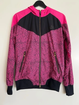 Träningsjacka Nike - Väldigt retro och cool träningsjacka från Nike.   Flera färger, rosa, svart, leopard print.   Den har nät på insidan av jackan, luvan, fickorna. Har bifogat bilder på det.