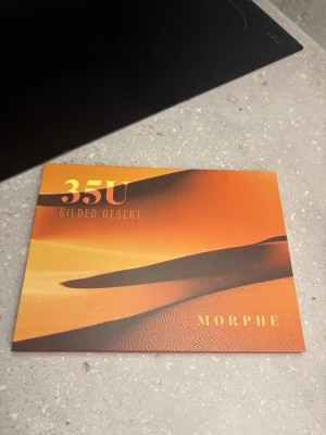 Morphe 35U Gilded Desert ögonskuggspalett - Morphe 35U Gilded Desert ögonskuggspalett med 35 nyanser i varma toner som guld, brons, brunt och beige. Paletten innehåller både matta och skimrande skuggor, perfekt för att skapa olika looks. Kommer i en snygg förpackning med ökenmotiv.