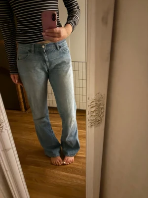 Ljusblå jeans  - Säljer ett par ljusblå jeans. Jeansen har klassisk femficksdesign, bälteshällor och stängs med knapp och dragkedja. Materialet är denim i bomull och de har en avslappnad vibe. Ingen strech i dom! 