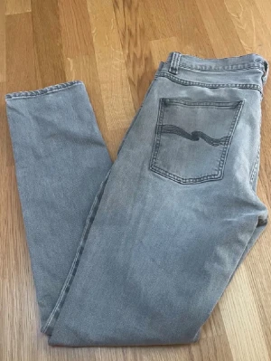 Grå Nudie Jeans Lean Dean - Feta nudie jeans I slimfit modellen lean dean, storlek 31/30. Jeansen har en liten fläck längst ner (se sista bilden), men det är ingenting man lägger märke till. Hör av er vid funderingar!