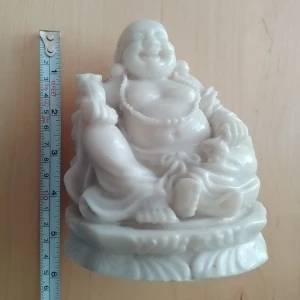Vit Buddha-statyett i marmor - Dekorativ Buddha-statyett i vit marmor med detaljer som pärlhalsband och traditionella kläder. Figuren har en rundad form med mjuka linjer. Perfekt som inredningsdetalj eller för dig som gillar asiatisk konst.