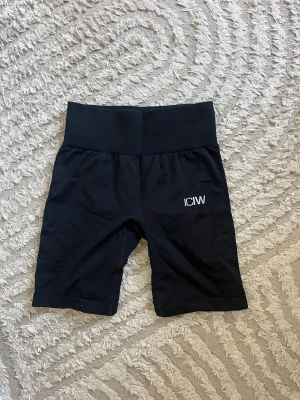 Svarta träningstights shorts från ICANIWILL - Snygga svarta träningstights shorts från ICANIWILL med hög midja och ribbad linning. Perfekta för gymmet eller löprundan. Stretchigt material som sitter skönt. De är använda väldigt få gånger så inga tecken på användning. 