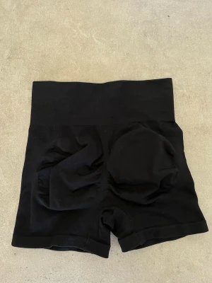 Svarta gymshorts - Svarta högmidjade gymshorts med scrunch. Säljer då de är för små för mig💕