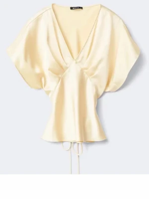 Ljusgul omlottopp i satin(använd 1 gång) - Snygg ljusgul omlottopp i satin med v-ringning och korta ärmar. Toppen har knyt i midjan för en feminin siluett och ett mjukt, glansigt material som känns lyxigt. Perfekt för dig som vill ha en chic och trendig look.