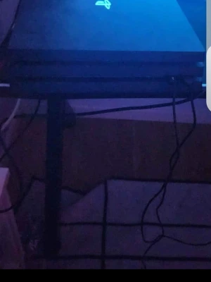 Playstation 4 Pro  - Säljer en Playstation 4 Pro i svart med tillhörande svart handkontroll som har orange LED-belysning. Konsolen har den klassiska fyrkantiga designen och är tillverkad i plast. Perfekt för gaming och streaming.