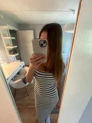 Randig vit och svart långklänning - Säljer en tight, ärmlös långklänning med svarta och vita horisontella ränder. Klänningen har en rak och kroppsnära passform. Materialet känns mjukt och stretchigt💕