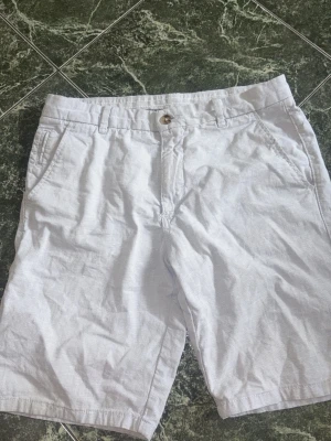 Kortbyxor - Säljer snygga kortbyxor från Cortefiel. Storlek S. Färg är ljusblå och knapparna är ljusbrun och beige. Skicket är bra, bara lite skrynkliga. Hör av dig vid flera frågor eller bilder!