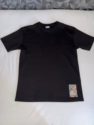 Designer T-shirts  - Säljer fem snygga t-shirts. Den svarta har en liten rutig detalj nertill och klassisk passform. Den vita har blått tryck och små slitningar upptill för en cool look. Båda har rund hals och korta ärmar, perfekta till jeans eller shorts.  Alla tröjor är av nytt skick och topp kvalité alla förutom Prada är helt oanvända och Prada är använd nån enstaka gång. Alla är i M förutom Prada som även passar S.