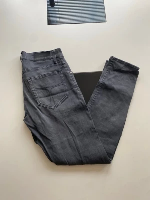 Grå slim fit jeans 30/32 - Snygga grå slim fit jeans i modellen Pistolero. Jeansen har klassisk femficksdesign, normalhög midja och raka ben. Materialet är mjukt och stretchigt för extra komfort. Perfekta för en avslappnad och trendig look.