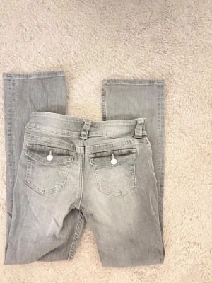 Grå bootcut jeans med dubbla knappar - LÅGMIDJAD‼️ H&M. Helt nya jeans, köpta i förrgår! Bilderna visar min systers jeans, men jag säljer ett par som är exakt likadana och helt oanvända.  💙 Pris: 210 kr 📏 Passar storlek XXS, XS och S.