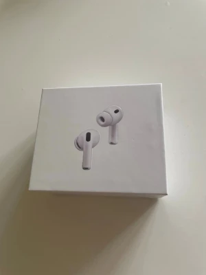 AirPods Pro 3 - Säljer ett par AirPods Pro 3 hörlurar i stilren design. Hörlurarna har silikonproppar och levereras i en kompakt, fyrkantig förpackning. Perfekta för dig som vill ha smidiga och moderna hörlurar till mobilen eller datorn. Airpodsen laddas av ett USB-C uttag och har även Noice cancelling.