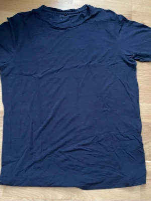 Mörkblå basic t-shirt Jack&Jones  XL - En enkel mörkblå t-shirt med rund hals och korta ärmar. Tillverkad i mjukt material som känns skönt mot huden. Perfekt att matcha med jeans eller shorts för en clean och avslappnad stil.