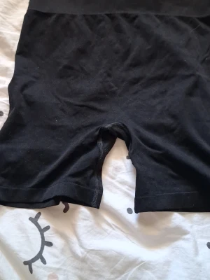 Svarta cykelbyxor leggings - Säljer ett par svarta cykelbyxor i stretchigt material. De har hög midja och korta ben, perfekta till sommaren eller under klänning. Klassisk och enkel design utan synliga loggor eller detaljer.