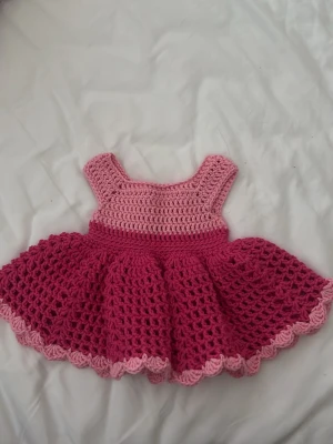 Rosa  bebis klänning - Hej, säljer denna egen virkade bäbis klänning, den är virkad för att passa 0-3 månader gammla. Se bilder för mått. Virkad med 100% bomullsgarn💗 skriv vid frågor.