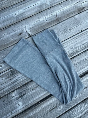 Grå leggings med bred midjeresår - Snygga grå leggings med bred midjeresår för extra komfort. Tillverkade i mjukt och stretchigt material som sitter skönt mot kroppen. Perfekta att matcha med oversized tröjor eller hoodies. Klassisk modell utan synliga loggor eller detaljer.