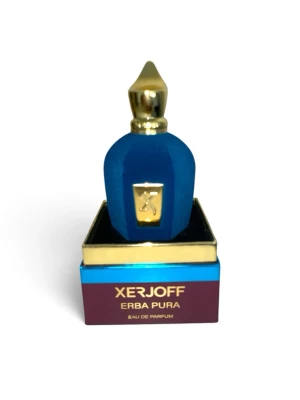 Xerjoff Erba Pura Eau de Parfum - Lyxig parfym från Xerjoff, Erba Pura, i en elegant blå flaska med gulddetaljer och matchande exklusiv förpackning. Flaskan har en unik form med guldfärgat lock och dekorativ platta framtill. Kommer i originalkartong med stilren design.