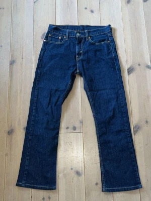 Levis bootcut jeans - Snygga mörkblå jeans med bootcut passform och klassiska fem fickor. Jeansen har kontrastsömmar och en patch bak i midjan. Tillverkade i denim med en tidlös look som passar till det mesta. Skick 10/10
