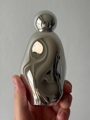 Cosmic Kylie Jenner 2.0 Eau de Parfum - Säljer en Cosmic Kylie Jenner 2.0 Eau de Parfum i en futuristisk, silverfärgad metallisk flaska med rundad form och klotformad kork. Flaskan rymmer 100 ml och har en unik, spegelblank finish som verkligen sticker ut i parfymhyllan. Använt kanske 3 gånger. 