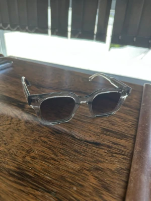 Chimi 04 grey  - Snygga solglasögon med rektangulära bågar i transparent grå plast och mörka glas. De har en modern och stilren look, lådan är tyvärr bort tappad!