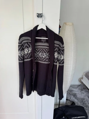 Mörkblå cardigan  - Säljer en mörkblå cardigan med riktigt snyggt mönster. Den är riktigt fint stickad och med ett väldigt snyggt mönster perfekt till hösten och vintern. Inga defekter