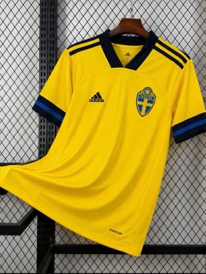 Svensk landslagströja Adidas gul - Gul svensk landslagströja från Adidas med blå detaljer och klubbmärke på bröstet. Tröjan har korta ärmar, blå krage och tre blå ränder på axlarna. Tillverkad i ett lätt och ventilerande funktionsmaterial, perfekt för fotboll eller träning.