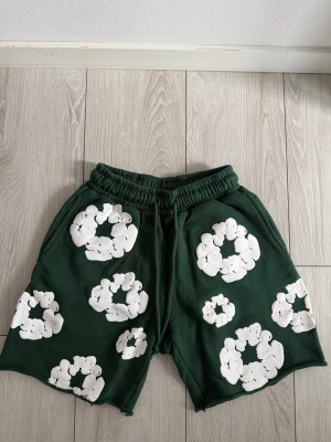 Denim tears shorts - Säljer dessa gröna shorts från Denim Tears, i absolut toppskick. Skicket är 10/10, endast provade och i princip helt ny. Perfekt till någon som uppskattar stilrena premiumplagg.💯  Säljes eftersom de inte används. Skicka gärna DM vid frågor eller om du vill ha flera bilder. Pris kan diskuteras.🔥