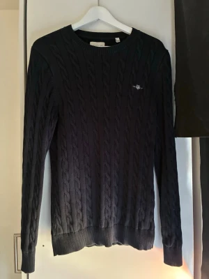 Navy blue tröja GANT - Navy blue stickad Gant tröja med gant märke på vänster sida, stilren och väldigt bekväm nu till hösten,