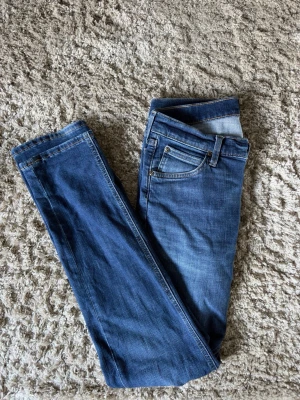 Lee Daren  - Säljer ett par klassiska blå jeans från Lee, modell Daren Zip Fly. Jeansen har fem fickor, dragkedjegylf och raka ben. Perfekta till vardagslooken med sin sköna och stilrena passform! 