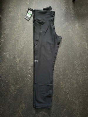 Under Armour leggings (Large) - Svarta ankle leggings från Under Armour med hög midja och kompressionseffekt.  Stl L                   Helt ny Nypris (599)