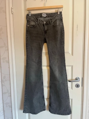 Grå bootcut jeans  - Snygga grå bootcut. Jeansen har en lätt tvättad look och vida ben som ger en retrovibe. Perfekta för dig som gillar en avslappnad men basic stil. Materialet är denim i bomull.