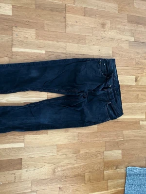 Svarta raka jeans grå från tiger of Sweden  - Säljer ett par svarta jeans med rak passform och klassisk femficksdesign. 