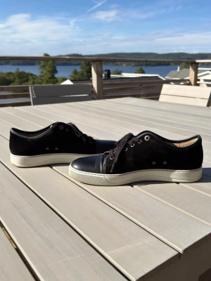 Lanvin  - Snygga och sparsamt använda Lanvin Nappa sneakers. Gjorda av kalvmocka och riktig gummisula, man känner kvaliteten. 100% äkta, köpta från Care Of Carl. Kvitto / orderbekräftelse finns. Använt typ 15-20 gånger på ett helt år. Nypris ligger på 5000+. Det är storlek 44 på dom men dom passar som 45, jag har själv storlek 45 på alla skor och dessa passar perfekt. 