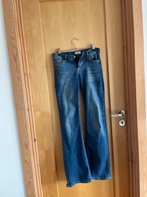 Blå bootcut jeans från ONLY - säljer ett par super snygga only jeans, som är lågmidjade. dem är trasiga längst ner vid benet. köpte för 800 men säljer för 300, pris kan diskuteras