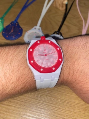 Speciell klocka  - Vit och rosa/ cherry färgad klocka. Finns i flera färger och armband. Lanyard och armband medföljer alltid. Pris går att diskutera. 