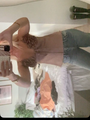 Beige mesh korsettopp med blommor - Trendig beige korsettopp i mesh med blommiga detaljer över bysten. Toppen är ärmlös och har en croppad passform som ger en snygg siluett. Perfekt för dig som vill sticka ut med en unik och feminin look.