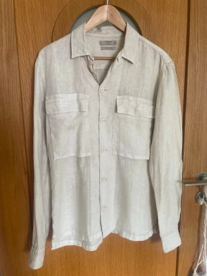 Mango beige overshirt i linnetyg, Storlek S  - Mango beige overshirt i linnetyg, Storlek S. Sitter avslappnat som overshirt och andas riktigt bra. Sparsamt använd och i väldigt gott skick. 