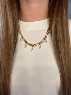 Guldhalsband med pärlhängen - Snyggt halsband i guldfärgad metall med kedja och flera vita pärlhängen som ger en trendig och elegant look. Perfekt accessoar för att lyfta din outfit med en touch av klassisk stil. Lätt att matcha med olika kläder och stilar. Rostfritt stål och handgjort 