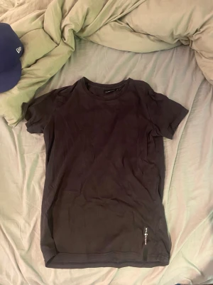 Svart t-shirt från Sail Racing XS - Svart t-shirt från Sail Racing i klassisk modell med rund hals och korta ärmar. Diskret logga nertill på framsidan. Perfekt för en clean och stilren look.