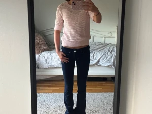 Ljusrosa stickad topp med kort ärm - Supersöt ljusrosa stickad topp med korta ärmar och rund hals. Toppen har ett diskret hålmönster och ribbade kanter vid ärmslut och nederkant. Perfekt för vår och sommar, enkel att styla till både jeans och kjol!💕