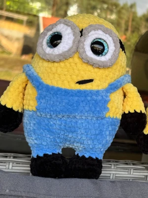 Minion mjukisdjur i blått och gult - Söt minion-inspirerad mjukisdocka i mjukt, fluffigt material. Dockan har stora broderade ögon, blå overall och svarta händer och fötter. Perfekt som dekoration eller leksak för dig som gillar animerade filmer.
