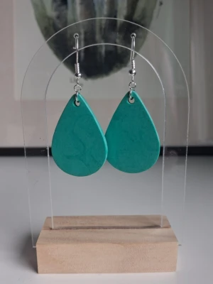 Jesmonite droppformade örhängen grön - Snygga egentillverkade örhängen i droppformad design med grön färg,skapade av jesmonite. Öronkroken är nickelsäker. Längd på droppen ca 3.5cm långa.