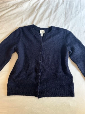 Mörkblå kofta från H&M - Fin mörkblå stickad kofta från HM, använd fåtal gånger.